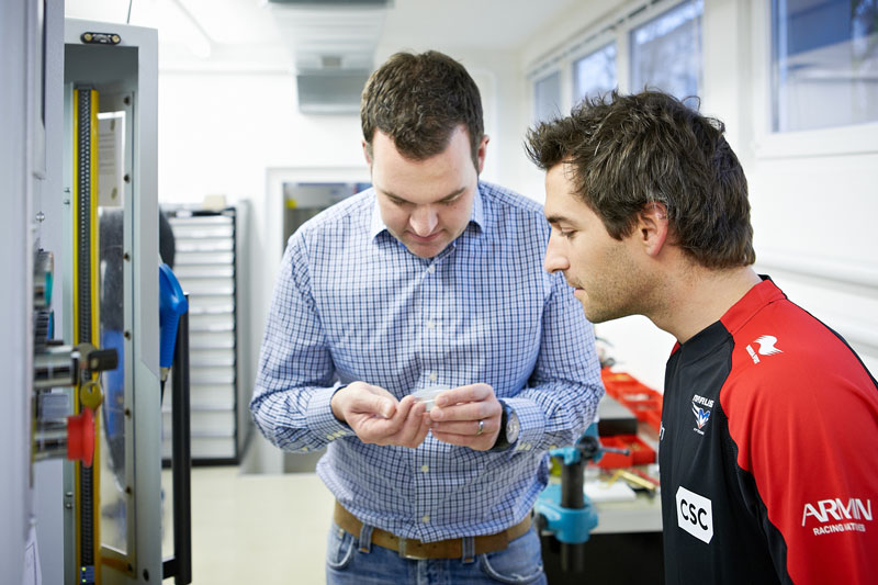 Claude Greisler, Head of Product development, shows Timo Glock the escapement crown  wheel pinion, which has just been produced  by the cutting machine.